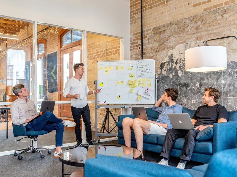 Four colleagues planning at a whiteboard